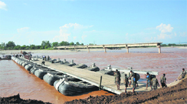 Soldiers build a pontoon bridge across the Tawi after damage to the existing bridge on the outskirts of Jammu on Tuesday