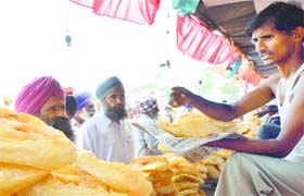 A vendor sells ‘khaja’, a traditional sweet, at the fair