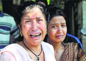 A woman gets emotional as she waits to meet her relatives outside the airport in Jammu
