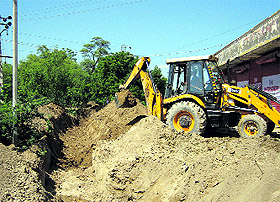 A JCB machine digs a water course to divert rainwater in Abohar.