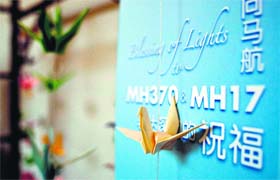 Origami paper cranes hang on a board offering prayers and condolences to the Malaysia Airlines MH370 and MH17 victims in Kuala Lumpur on Tuesday