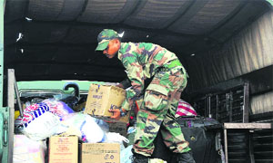 A jawan loads a truck with relief material for residents of flood-hit Jammu and Kashmir, at the military station, Dholewal, in Ludhiana.