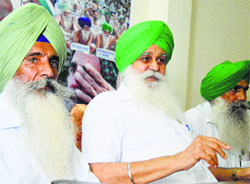 BKU president Ajmer Singh Lakhowal (centre) addresses a press conference in Ludhiana.