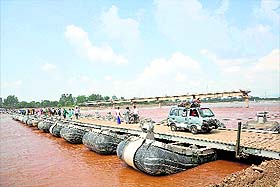 People use the pontoon bridge to cross the Tawi on Wednesday.