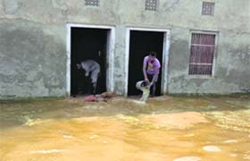 Residents drain out rainwater from their houses in Fatehpur Manian village in Lambi