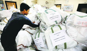 A worker of the Gujarat State Disaster Management Authority arranges food packets in Ahmedabad before dispatching them for flood victims in J&K on Thursday.