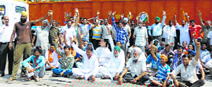 Shopkeepers hold a dharna on the Malout highway in Abohar on Thursday. Tribune Photo