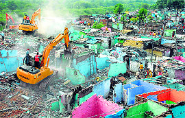Earthmovers pull down illegal structures during a demolition drive at Madrasi Colony, Sector 26, Chandigarh, on Friday