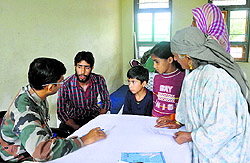 Abdul Rashid Malik volunteers as a translator for Kashmiri patients and a doctor at a medical camp in Manasbal on Friday