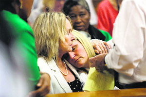 June Steenkamp (left), mother of Reeva Steenkamp, holds her cousin Kim Martin as the judgment is handed down in the murder trial of South African Paralympic athlete Oscar Pistorius in the high court in Pretoria on Friday