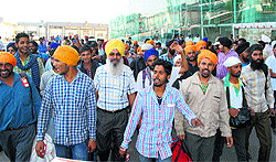 Rescued flood victims walk out of the Sri Guru Ramdass International Airport in Amritsar on Saturday