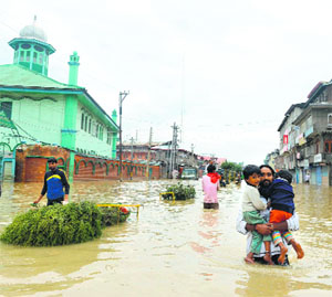 Locals wade through floodwaters in central Srinagar on Saturday.