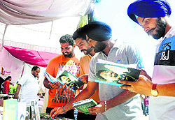 Youths take a glance at books in a stall at Kisan Mela