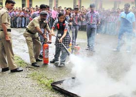Personnel of the state fire and emergency services demonstrate fire safety measures to students at KVFRI in Dehradun