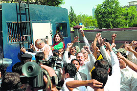 Activists of Pakistan Tehreek-e-Insaf gather around a police prison van carrying arrested workers to prevent them from leaving the court area in Islamabad on Saturday.