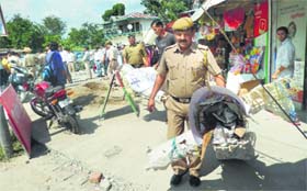 The police remove the effigies of the CM and the Chief Parliamentary Secretary, Education, from the College Chowk in Kangra on Saturday.