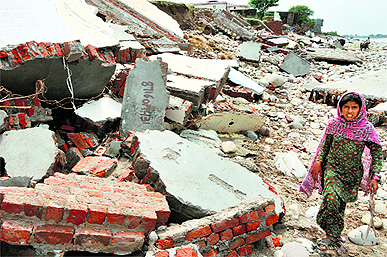 A girl walks through the debris of her house in Jammu on Friday. 