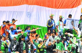 Indian and Pakistani fans, all British citizens, raise the flags of the country during a match in Birmingham