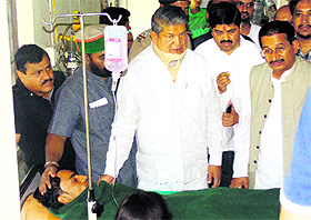 Chief Minister Harish Rawat inquires about the condition of victims of the Juyalgarh bus accident at the base hospital in Srinagar on Sunday. 