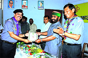 Education Minister Mantri Prasad Naithani gives away a badge of honour to Bharat Scouts and Guides State Headquarters Commissioner Rajeev Sharma in Dehradun on Sunday. 