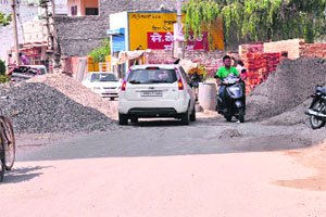 The construction material lying in the middle of Ajit Road in Bathinda on Monday.