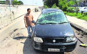 The damaged Alto car that hit an unlevelled road next to a manhole near Narinder Cinema at Jalandhar on Monday.