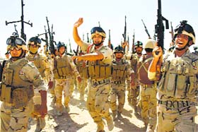 Iraqi soldiers brandish their weapons during a military exercise in Basra.