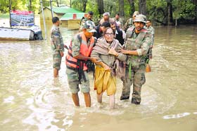An old woman being helped by troops after disembarking from a boat in Srinagar