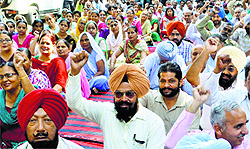 Staff of the PSPCL and the PSTCL hold a protest at the zonal office against the proposal to acquire 32 acres for commercial exploitation in Ludhiana on Tuesday