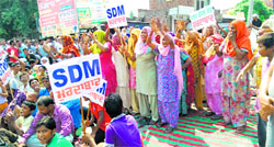 People protest against the overflowing sewage in Jaitu on Tuesday. Tribune photo