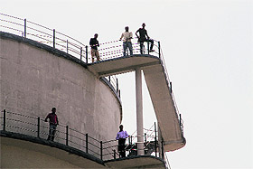 UPNL employees at the top of a water tank in Dehradun on Tuesday.