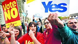 Pro and anti-independence supporters wave posters outside a campaign event