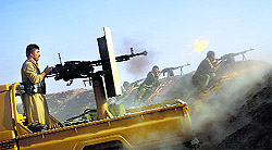 Kurdish fighters fire a Duskha heavy machine gun in the Gwer district, 40 km south of Arbil in northern Iraq