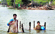 Pakistani residents wade through floodwater in Sher Shah, a town in Multan district