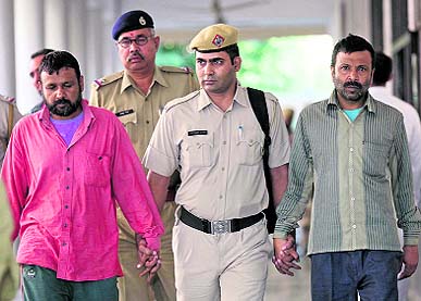 The accused, Shaukeen (extreme left) and Salim, come out of a Panchkula court on Wednesday.