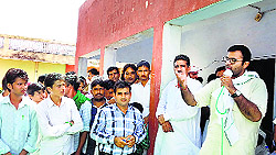 INLD leader Karan Singh Chautala addresses a meeting at Badopal village on Wednesday as Balwan Singh Daulatpuria, INLD candidate from Fatehabad, looks on