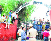 Amb SDM and DSP look on as agitating students of Government College, Daulatpur Chowk, deny them entry into the campus.