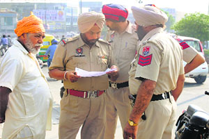 Police officials inspect the crime scene on Jagraon Bridge in Ludhiana. 