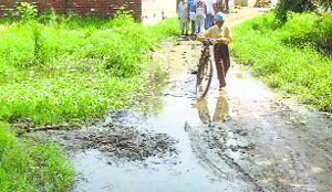 A boy makes his way through a waterlogged street at Nangal village near Ahmedgarh.