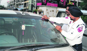 The Traffic Police removes unauthorised stickers of press from the vehicles of the offenders during a checking drive in Amritsar on Thursday