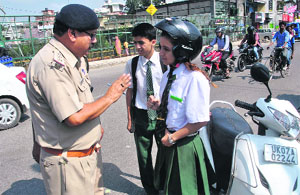 A policeman explains traffic rules to schoolchildren in Dehradun on Thursday.