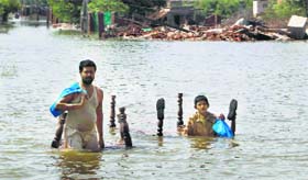 Residents wade through floodwaters in Multan district.