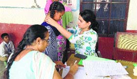 A doctor examines a student at a government school.