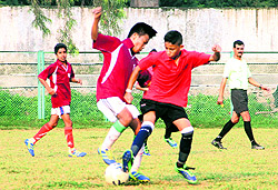 Players vie for the ball during a match in the U-14 Boys District Football Tournament at Pavilion Ground in Dehradun on Friday