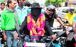 Ace magician Shankara rides a motorcyle with his face and eyes covered in Haridwar on Friday to generate awareness about the art of magic