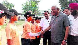 Sports Minister Dinesh Aggrawal shakes hands with a player during the opening ceremony of the 13th Little League National Baseball Championship at Rangers Ground in Dehradun on Friday