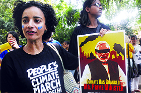 A participant shows a poster bearing an illustration of Prime Minister Narendra Modi as she takes part in the People's Climate March in New Delhi on Saturday to draw attention towards the issue of climate change, ahead of the UN Climate Summit to be held in New York. Various groups are organizing the march all over the world ahead of the summit. 