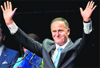 New Zealand Prime Minister John Key waves as he makes a speech after victory, in Auckland on Saturday. AP/PTI 