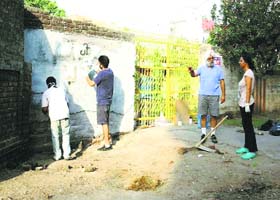 Volunteers draw a caricature after cleaning a stretch on the Lawrance Road in Amritsar