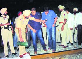 The police examine the spot where head constable Raj Kumar was crushed under a train in Amritsar on Sunday